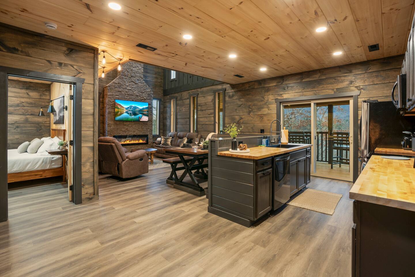 Open kitchen with island, dining area, and bedroom doorway